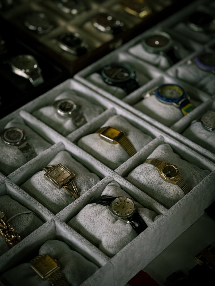 A curated collection of luxury watches displayed in neatly arranged boxes.
